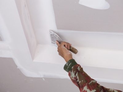 hand-of-worker-using-gypsum-plaster-ceiling-joints-picture-id637855762